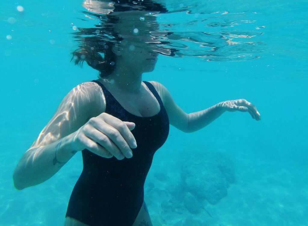 Woman underwater practising breath control during swimming session